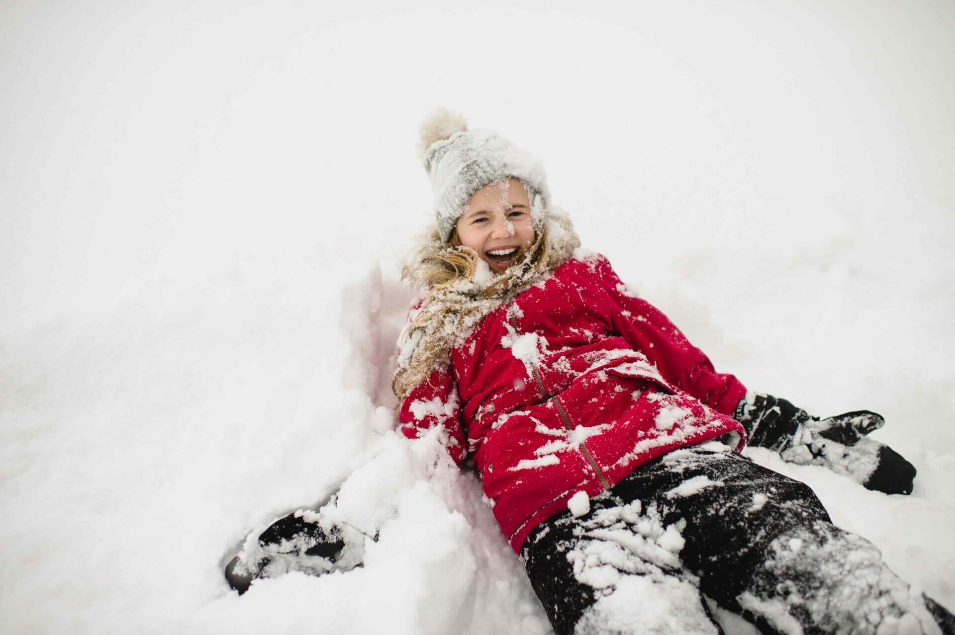 smiling girl lying on back and covered in snow 2022 03 04 01 45 08 utc