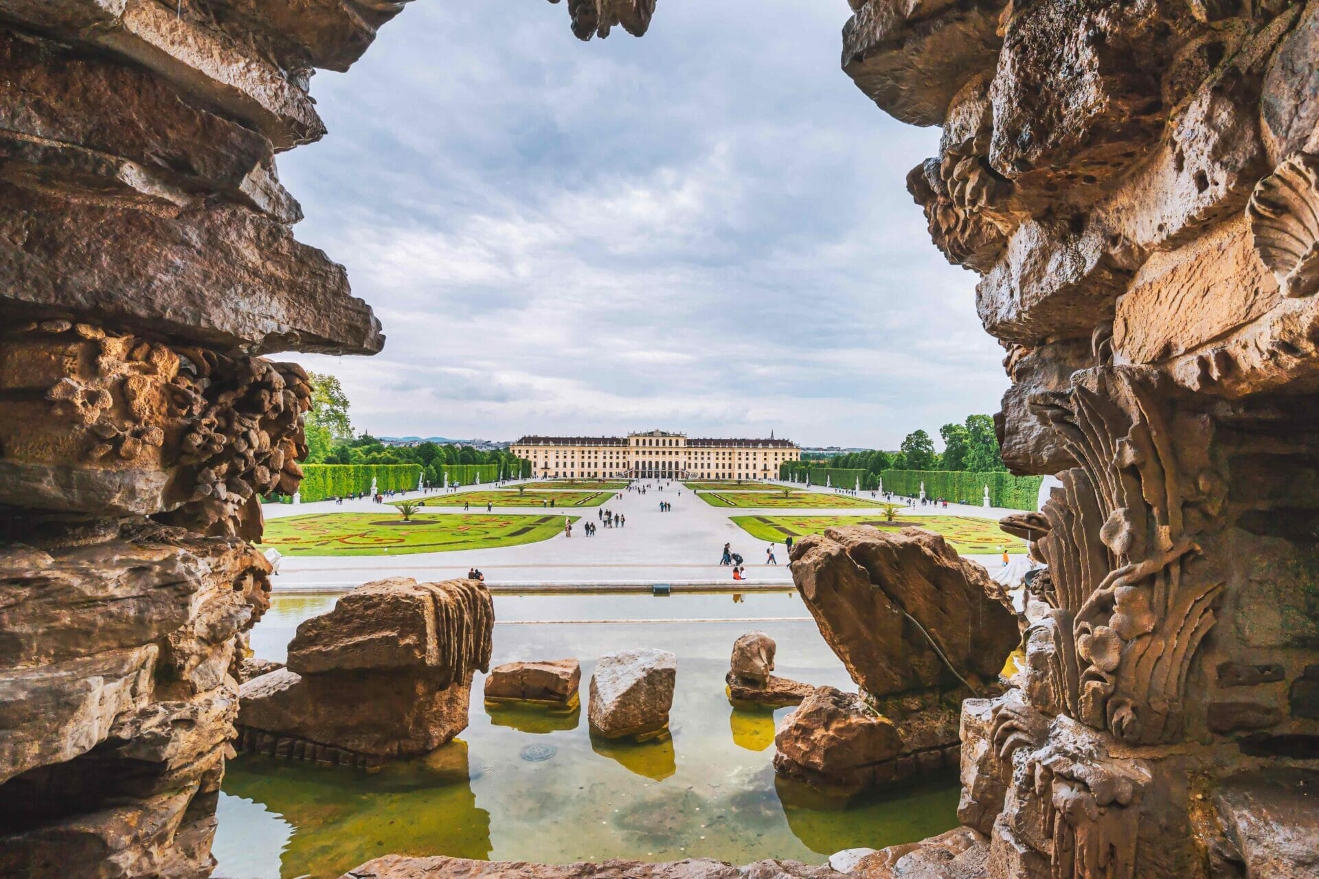 Vienna, Austria. Schonbrunn Palace or Schloss Schoenbrunn framed by fountain shape. Imperial residence in Vienna and a major tourist attraction in Vienna.