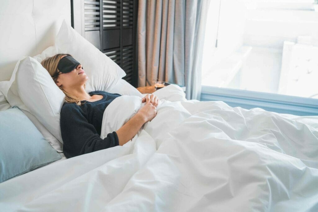 Traveler relaxing and peacefully sleeping with sleep mask at hotel room.