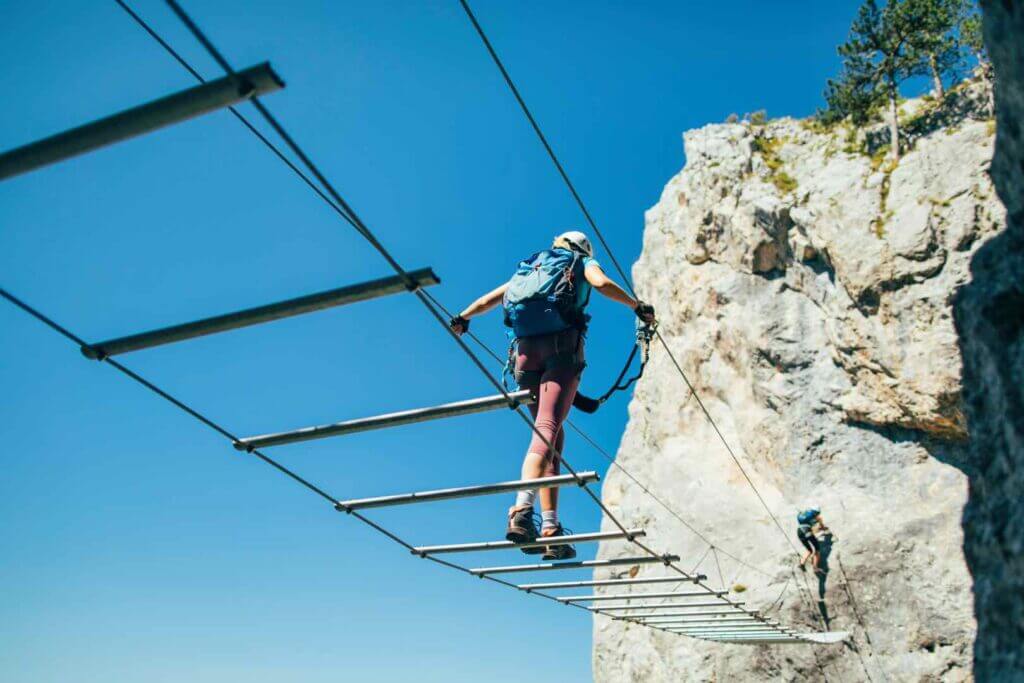 A couple of rock climbers scaling a cliff.