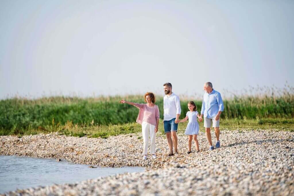 Multi-generational family enjoying a beach sunset together, radiating happiness and connection.